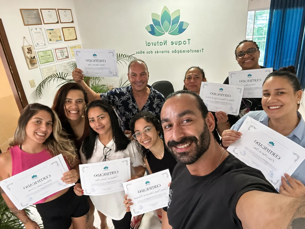 Turma formada no curso presencial da Toque Natural exibindo seus certificados